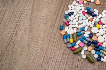 Different pills on wooden background. close up.