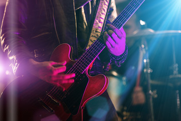 Obraz na płótnie Canvas A rocker is playing guitar on stage.
