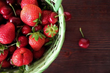 Basket with fresh strawberries and cherries  