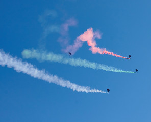Paratroopers with multi-colored smoke in the sky during the airshow