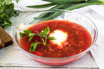 Vegetables and meat in red beetroot soup or borsch with sour cream