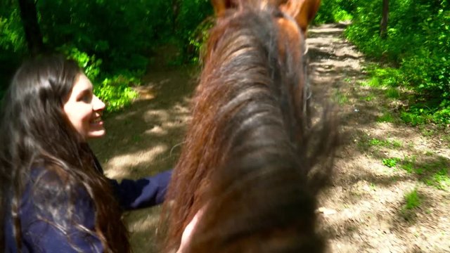 Person riding a horce in the forest with the instructor