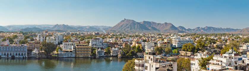Fototapeta na wymiar Beautiful panoramic view of Udaipur city in Rajastan, India. Famous Pichola Lake, historical buildings with mountains on background