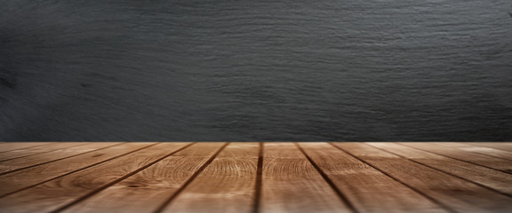Wooden table with a slate wall