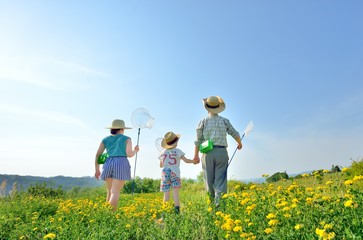 青空の草原で遊ぶファミリー