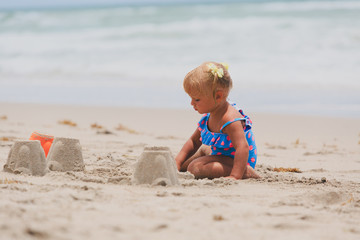 cute little girl play with sand on beach