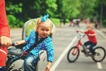 Fototapeta na wymiar mother with two kids riding bikes in the city