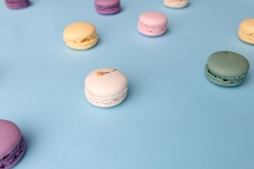 Sweet colorful macaroons on blue table background.