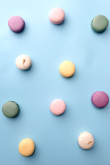 Sweet colorful macaroons on blue table background.