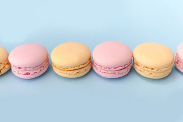 Sweet colorful macaroons on blue table background.