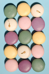 Sweet colorful macaroons on blue table background.