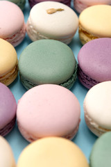 Sweet colorful macaroons on blue table background.