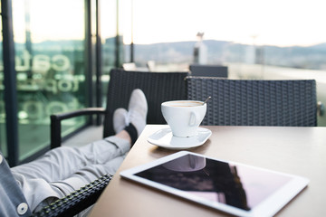 Unrecognizable businessman with a tablet in rooftop cafe