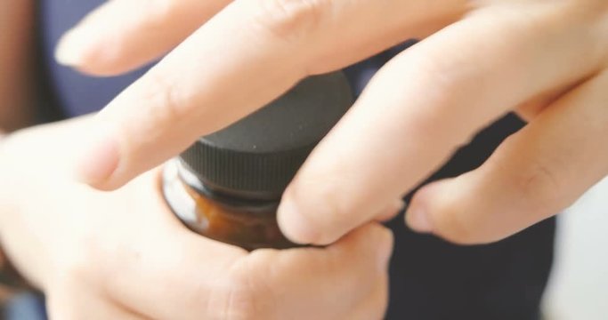Woman open pill bottle with her hand closeup