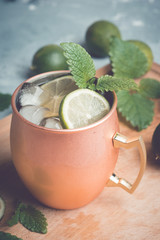Cold Moscow Mule cocktail in copper mug on the rustic background. Shallow depth of field. Toned image.