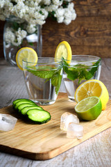 Water with lemon,lime  mint and cucumber on the wooden dark background. Water Detox.on wooden background