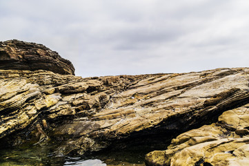Rock wall formation with gloomy sky
