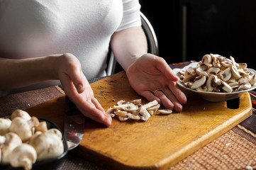 man cutting mushrooms on wooden cutting board
