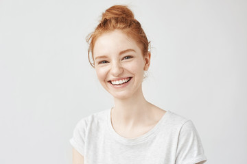 Portrait of cheerful redhead girl with hair bun laughing. - 155048490