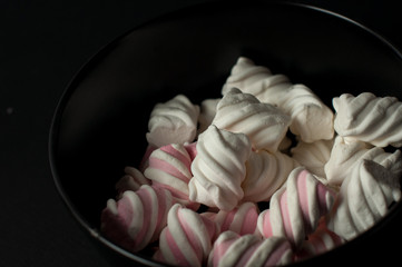 Marshmallows on black background with copyspace. Flat lay or top view. Background or texture of colorful mini marshmallows.