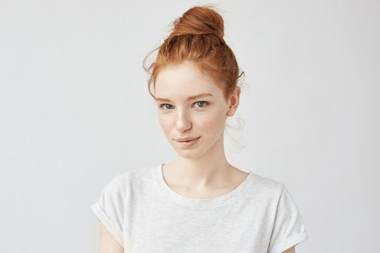 Beautiful ginger model with trendy bun biting lip.