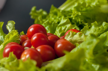 Healthy vegetarian Salad cherry tomatoes and lettuce on the black plate