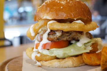 Huge beef burger with fried onion and tomato 