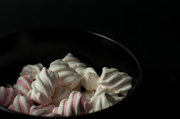 Marshmallows on black background with copyspace. Flat lay or top view. Background or texture of colorful mini marshmallows.