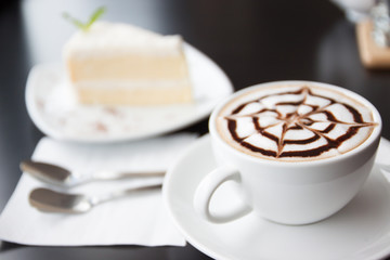 Cappuccino coffee in white cup and cake