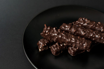 Chocolate waffles with nuts on a black background.