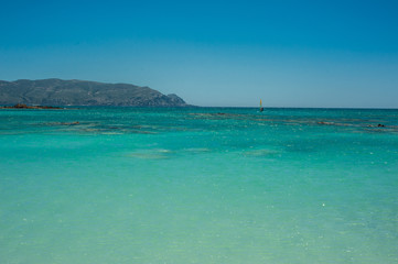 Fototapeta na wymiar Windsurfer on the turquoise water, Elafonisi pink beach Greece, Crete