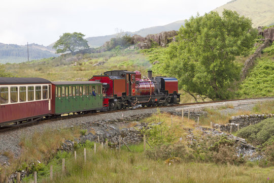 Fototapeta UK - Wales - Red steam locomotive (class garratt) pulls the old heritage train through Wales wilderness on Welsh Highland Railway