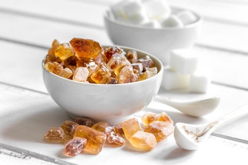 variety of sugar in bowls on white wooden table background