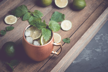 Cold Moscow Mule cocktail in copper mug on the rustic background. Shallow depth of field. Toned image.