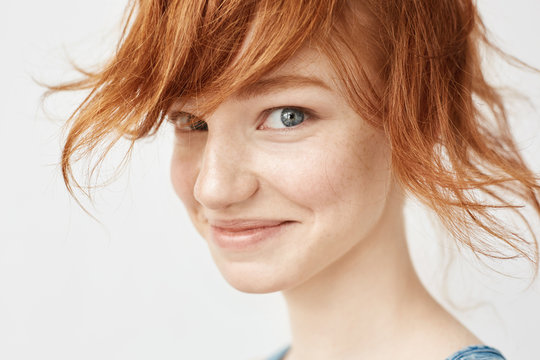 Close up portrait of funny redhead girl smiling looking at camera.