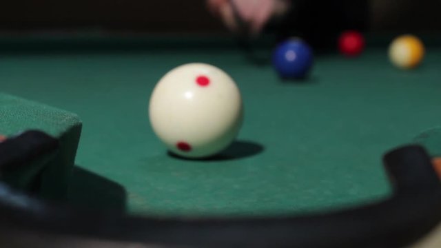 Yellow billiard ball number 1 next to the hole, close up. Player with white ball throws yellow ball in the hole. American billiard, 9-ball, nine-ball pool.