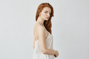 Fototapeta premium Beautiful redhead model in sleepwear posing looking at camera.