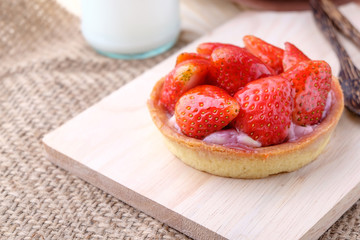 Tart with fresh strawberry on wooden background,