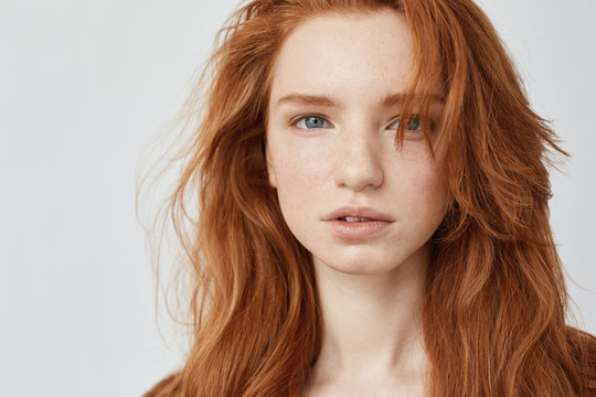 Close up of beautiful natural redhead model looking at camera.