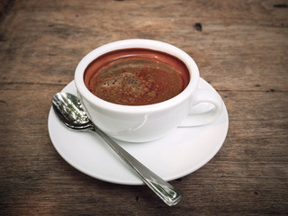 Cup of fresh coffee on wooden background, top view