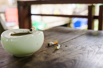 cigarette with ashtray on wood table.