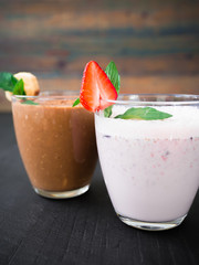 Blueberry smoothie with strawberry and banana smoothie on dark wood background. Fresh tasty milkshake