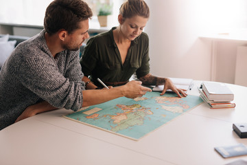 Fototapeta premium Young couple exploring the world map..