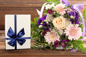 Blue gift box with beautiful bouquet of flowers