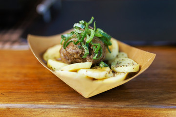 Meatballs with potatoes in a food truck.