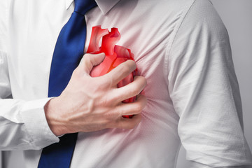 Heart attack concept. Young man suffering from chest pain, close up