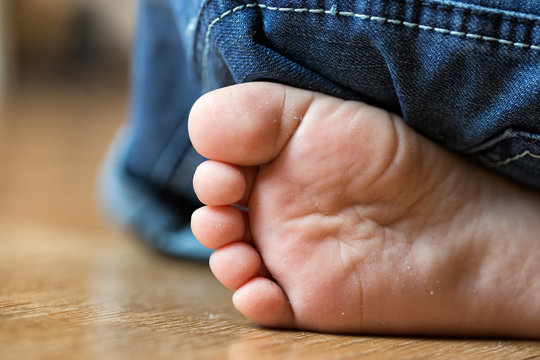 Barefooted foot of the child smeared in house dust