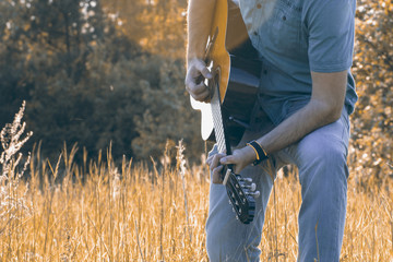 Men is playing on th guitar in nature