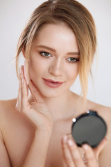 Obraz na płótnie Canvas Face Make-Up. Female With Mirror Putting Cosmetic Powder