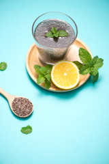 Selective focus of chia seeds drink with water in transparent glass with lemon balm.